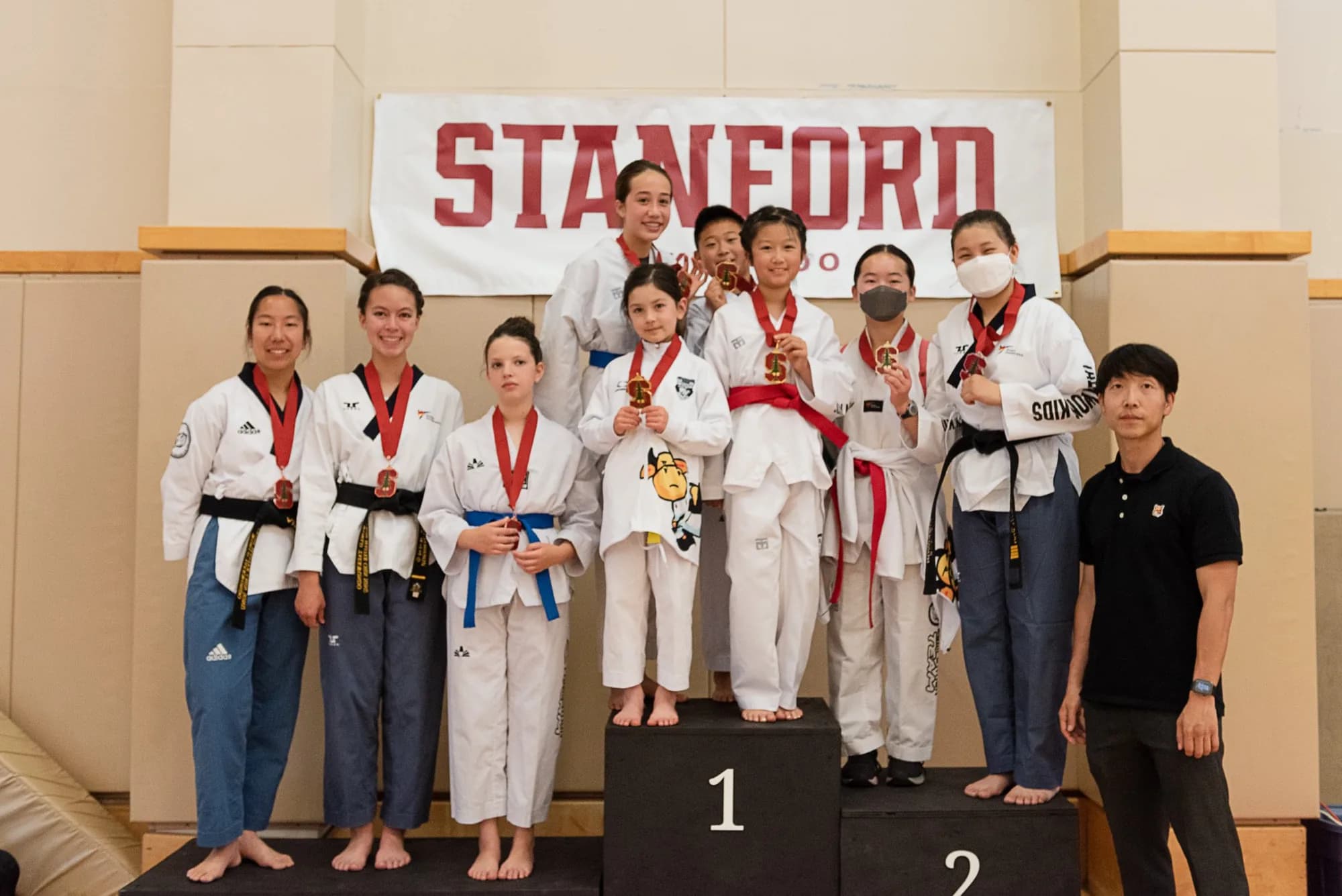 Students from Master Lee's previous school on the podium at a Stanford Taekwondo tournament